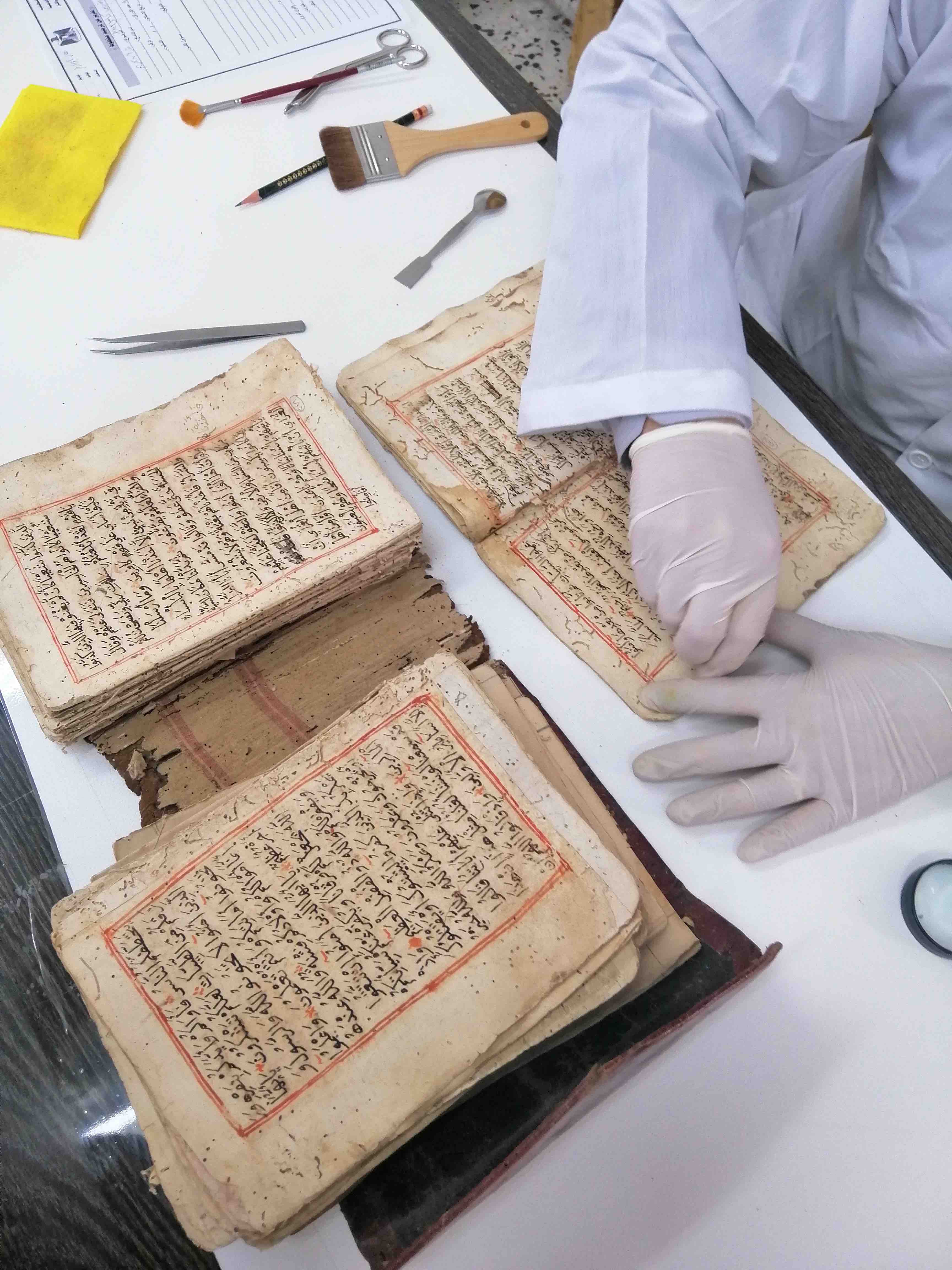 Technician cleaning a manuscript in preparation for digitization